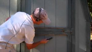 man scraping paint